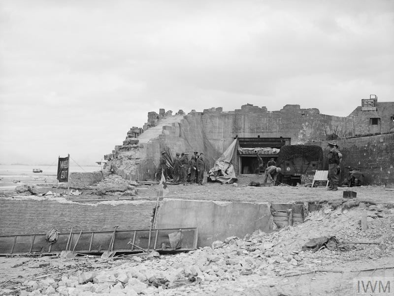 La 2 ième armée britannique : les commandos de la Royal Navy du LCOCU (Landing Craft Obstacle Clearing Unit) examinent une grande casemate et son canon de 88 mm qui faisait partie du point fortifié allemand WN33 sur le bord ouest de La Rivière, et qui a causé des problèmes considérables aux forces débarquant sur la plage « King », zone GOLD, avant d'être réduit au silence.
© Imperial War Museum